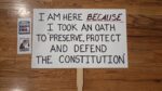Protest sign that says, "I am here *because* I took an oath to 'preserve, protect and defend the Constitution.'"