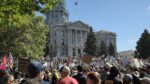 A view of numerous protestors in front of the Colorado Capitol.