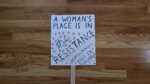 Protest sign that says, "A woman's place is in the resistance - democracy dies in silence."